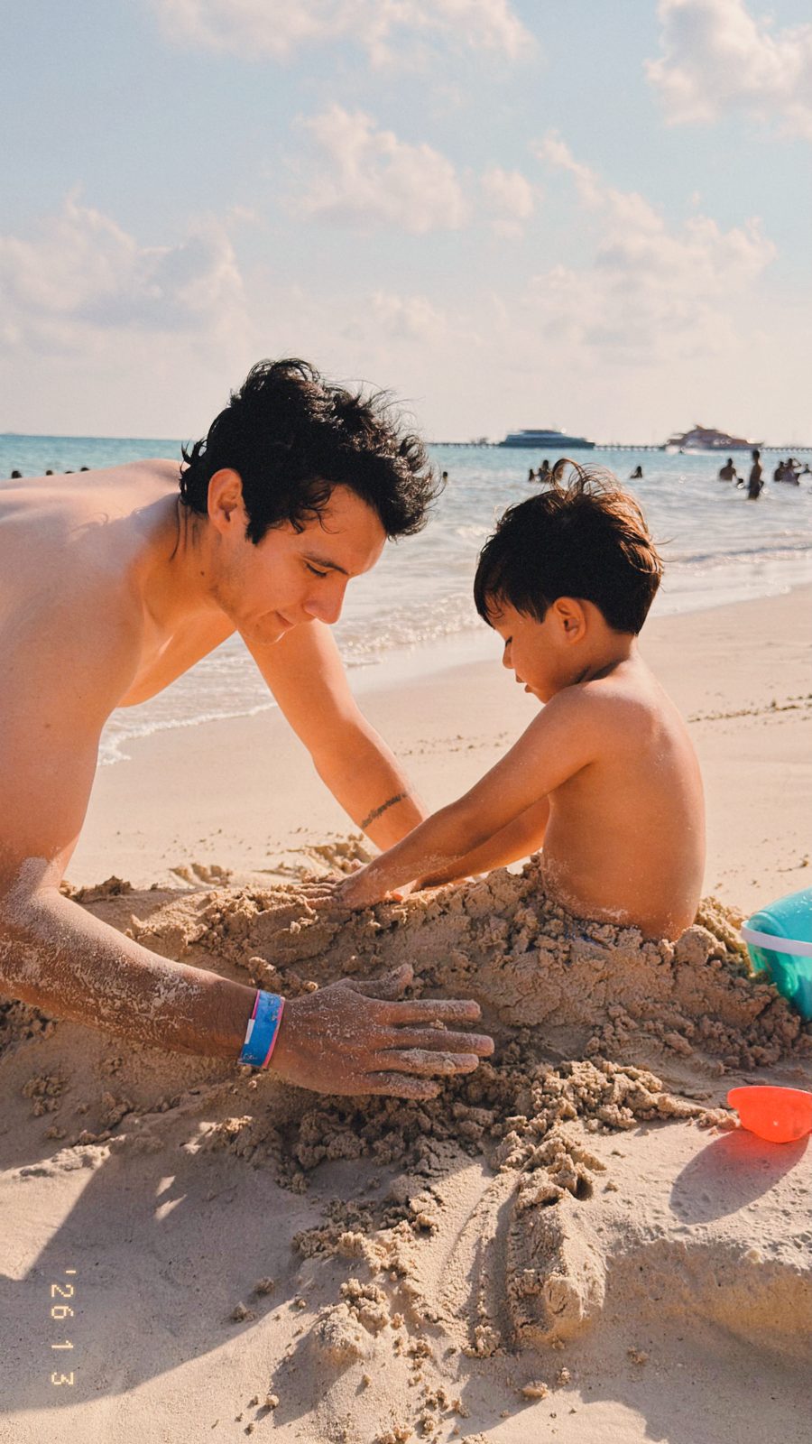 Victor jugando en la arena con su hijo